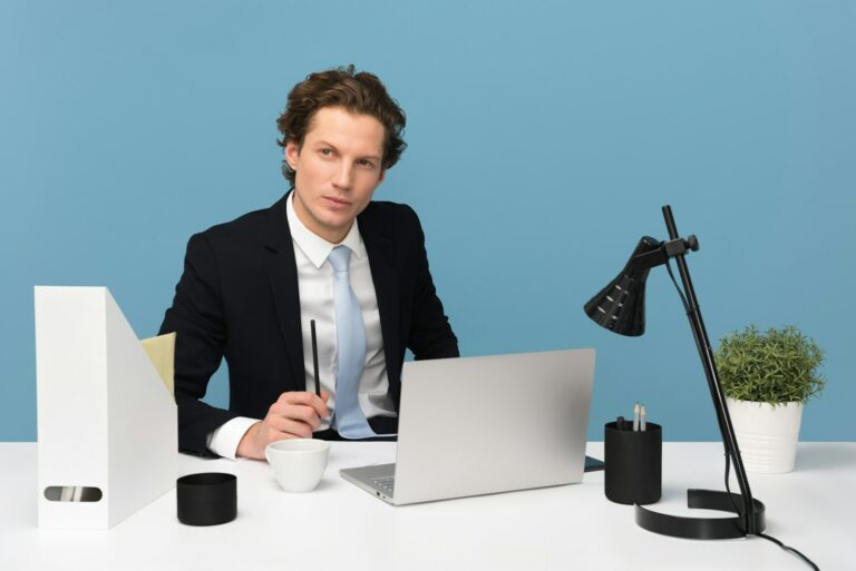 mężczyzna siedzi przy biurku z laptopem